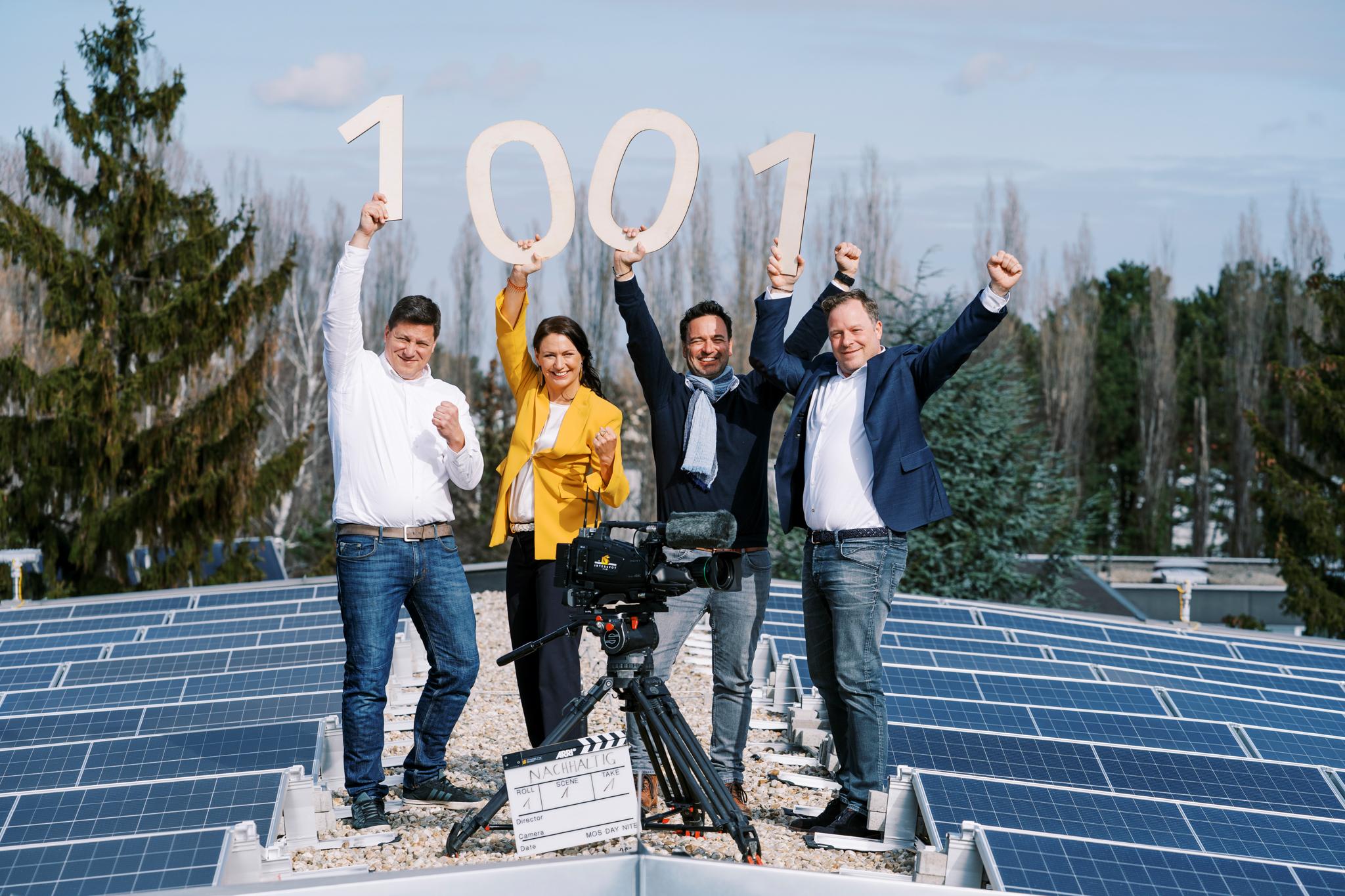 Konsortium hält die Zahl 1001 auf einem Photovoltaik-Dach in die Höhe